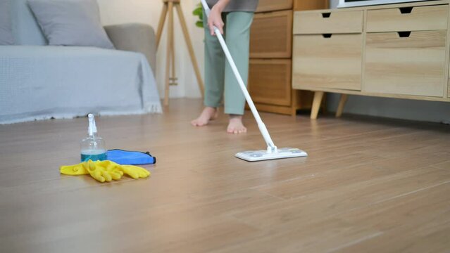 housewives use power-saving tools to clean the house to make the housework faster and cleaner, Asian woman wears rubber gloves while cleaning various furniture in her home with cleaning solution.