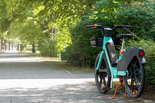Bike Sharing System. Electric E-bike Parked in Green City. Modern Electro Bicycle Ebike Rental in Eco City. Copy Space.
