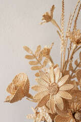 Obraz premium The bouquet flowers is made of straw on a white background. Straw weaving
