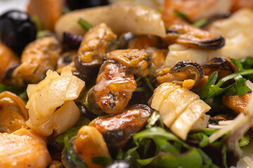 Close-up of seafood salad with herbs and olives. Macro