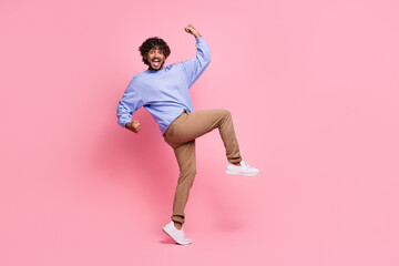 Full size photo of nice young guy raise fists have fun lottery wear trendy blue outfit isolated on pink color background