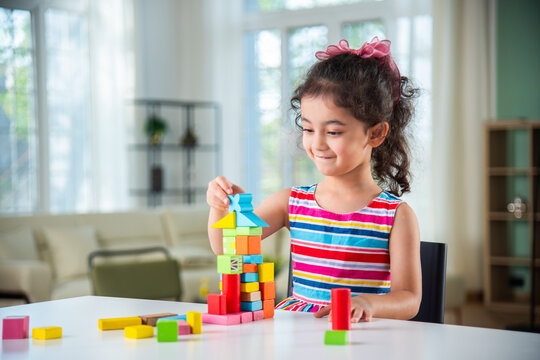 Indian asian child preschooler girl playing wooden toys at home or kindergarten