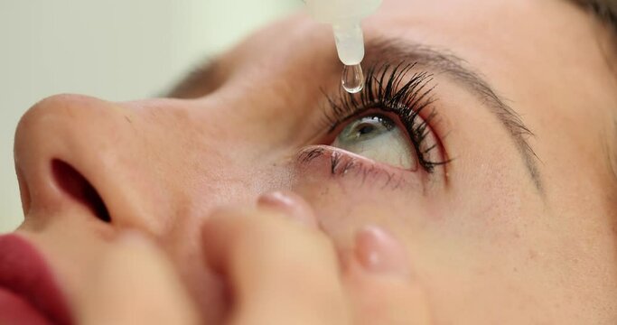 Woman with vision problems drips medical drops onto eyeball
