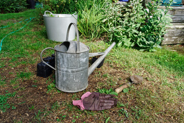Garden planting. Empty pots, gloves and a trowel lie on the lawn.