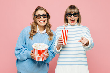 Elder parent mom young adult daughter two women wearing blue casual clothes 3d glasses watch movie film hold bucket of popcorn cup of soda pop in cinema isolated on yellow background. Family concept.