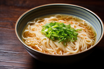 Traditional Japanese udon noodle soup in a ceramic bowl on wooden background.