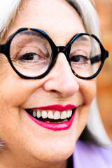 close-up portrait of a beautiful senior woman smiling happy looking at camera, concept of elderly people happiness and active lifestyle