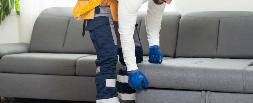 the man fixes the sofa.