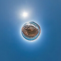 simple tiny planet without buildings in blue sky with beautiful clouds. Transformation of spherical panorama 360 degrees. Spherical abstract aerial view. Curvature of space.