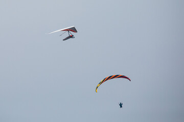 Flying in the sky. Paraglider and 
hang glider in the air