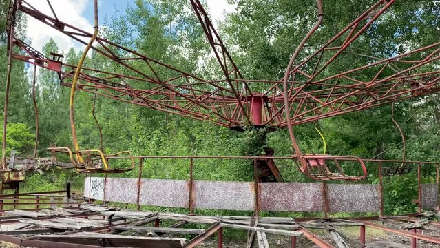 Eerie scene of an abandoned amusement park: a rusting merry-go-round overtaken by nature