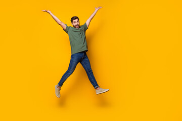 Full size photo of handsome young guy jump raise hands dressed stylish khaki outfit isolated on...
