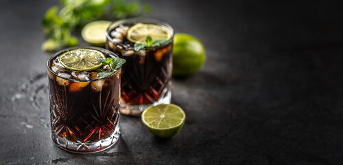 Tropical alcoholic cocktail Cuba Libre composed of white rum, cola, ice cubes, lime and mint - 752844116