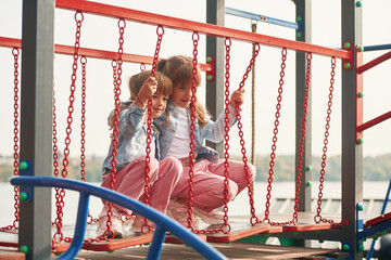 Enjoying swing ride. Kids are having fun on the playground