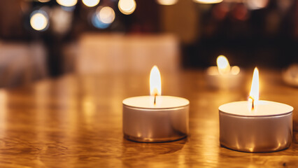 Obraz na płótnie Canvas Candles on Wooden Table in Warm Scene With Bokeh Background