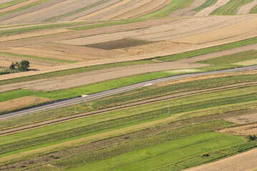 Suloszowa village in Krakow County. Aerial drone view of growing grain in the fields. Beautiful village with houses and fields in Poland. Village in the middle of the field from drone aerial view.