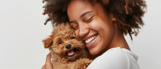 Joyful woman cuddles with her adorable poodle puppy, sharing affection.