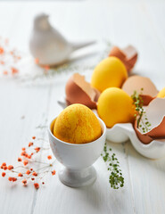 Easter composition with yellow eggs and flowers. Natural dyed colorful eggs and spring flowers rustic composition. Close up. Happy Easter concept.