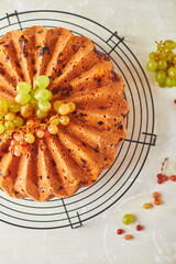 Delicious homemade grape sponge cake with noble mold cheese on a stone background.