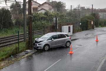 Colisão impactante: Automóvel choca contra poste numa gélida e chuvosa manhã de Inverno - obrazy, fototapety, plakaty