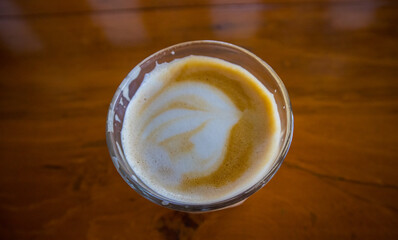 hot latte with latte art in wooden background