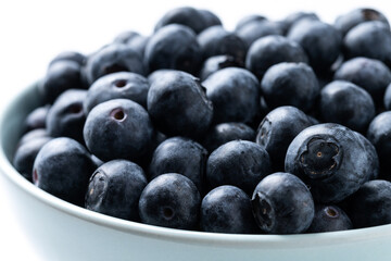 Blueberries in green bowl isolated on white background. Close up
