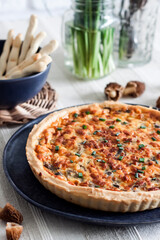 Quiche - open tart pie with morel mushrooms, onion and cheese on a plate
