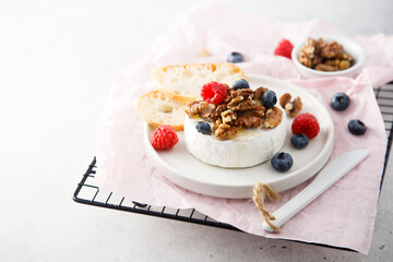 Baked camembert cheese with nuts and berries