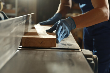 Professional carpenter working with wood in shop, closeup