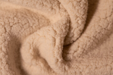 Top view of white soft sheepskin textile plaid. Warm cozy texture background