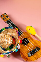 Mexican holiday background. Sombrero, maracas and guitar on pink background. Top view.