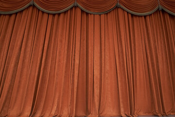 Orange closed curtain or drapes in theater with copy space. Theatrical performance concept. High...