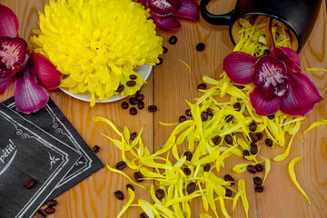 Scattered coffee beans. a cup of black coffee, espresso. orchid flowers. bouquet of yellow...