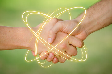 Freunde geben sich die Hand. Gelbe Neonleuchtspur umkreist die Hände. Nahaufnahme der Hände vor...