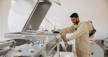 Portrait of happy young Indian beekeeper working in beekeeping factory