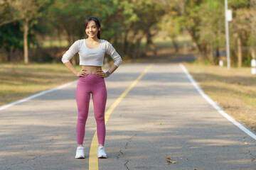 Young female runner stretching arms before running in the morning. Women stretch to warm up before running or working out. Fitness and healthy lifestyle concept.