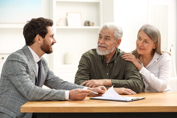 Notary consulting senior couple about Last Will and Testament in office