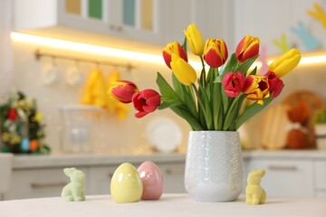 Bouquet of tulips and Easter decorations on white table indoors, closeup