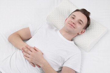 Obraz na płótnie Canvas Man lying on orthopedic pillow in bed