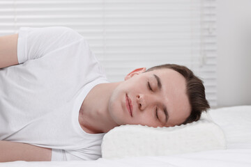 Fototapeta na wymiar Man sleeping on orthopedic pillow at home