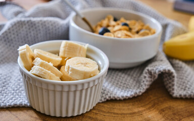 Bowl with slices banana and muesli on wood table. Healthy eating, healthy lifestyle