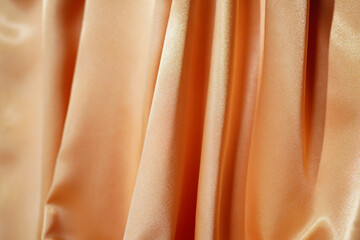 Yellow silk satin. Drape fabric. Gold color. Elegant background. Beautiful wavy space for design, blurred or blurred.