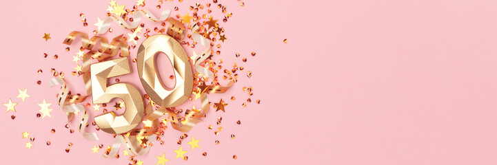 Banner with golden number fifty, ribbons and stars confetti on a pink pastel background. Festive...
