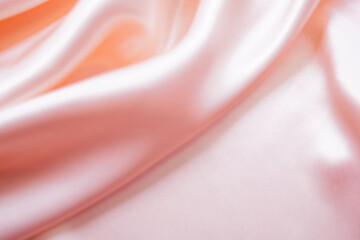 Light pink silk or satin wavy background beautiful and luxurious Space for design. Close-up....