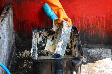 Grease traps from dirty debris being cleaned with a scoop are discarded. How to treat water with a grease trap.