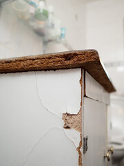 Old worn out cabinet with British style separate tabs for water and sink made of chip wood and in...