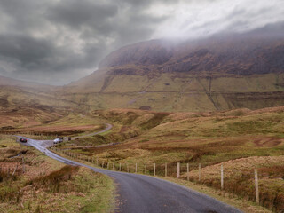Tall mountain and farm land under low cloudy sky. Stunning nature scenery of Horseshoe drive, county Sligo, Ireland. Amazing Irish landscape. Popular travel landmark.
