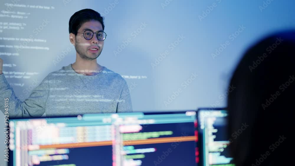 Wall mural a male software developer is in the midst of a presentation, gesturing expressively with a monitor d