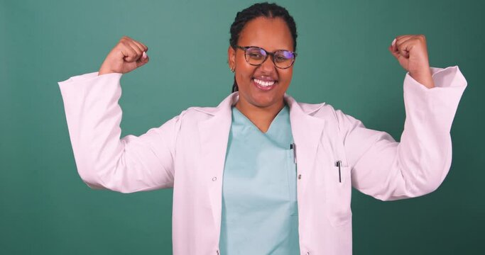 Beautiful young Black doctor flexes arm muscles, strong woman empowerment