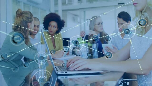 Animation of network of connections with icons over diverse colleagues having meeting in office